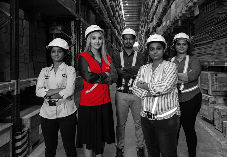 Group-of-workers-posing-among-boxes-in-warehou.jpg